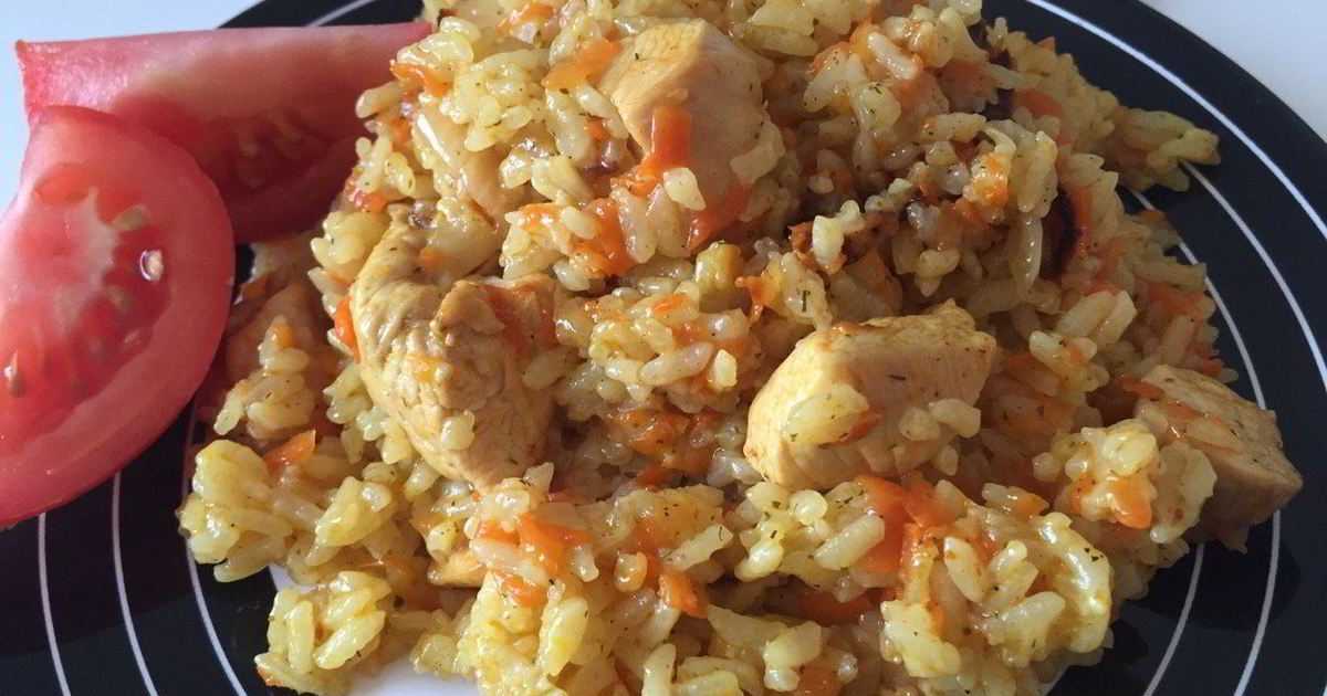 Рассыпчатый плов с курицей в кастрюле на плите